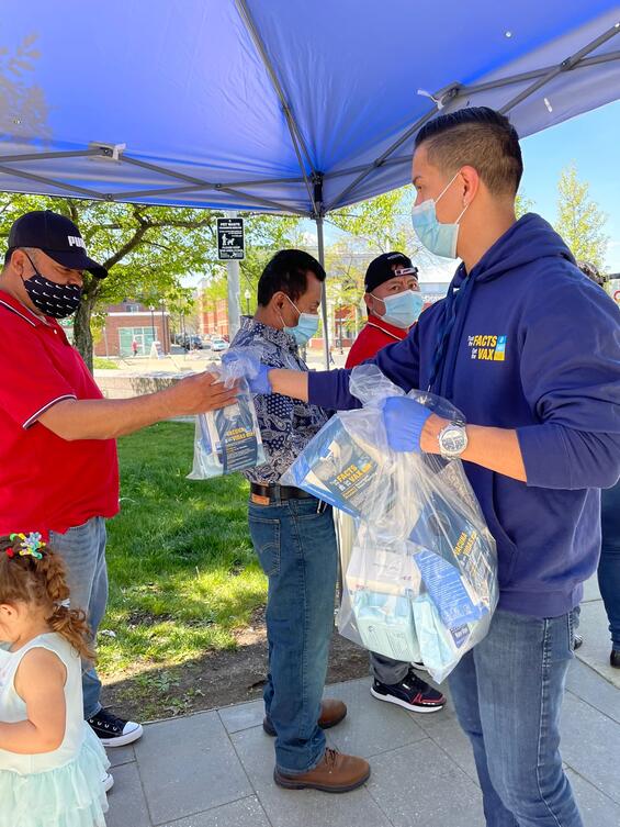 Vaccine Equity Initiative outreach workers hand out vaccine materials in East Boston.