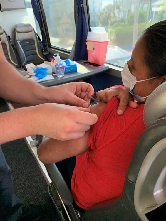 Person applying a bandage following vaccination.