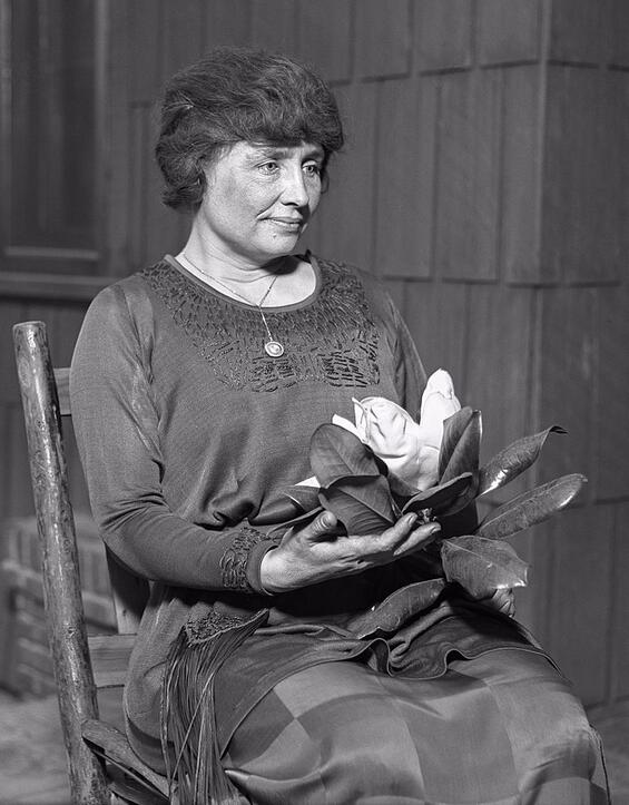 Helen Keller holding a magnolia circa 1920
