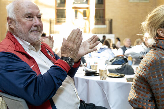 A seated man clapping at the ceremony.