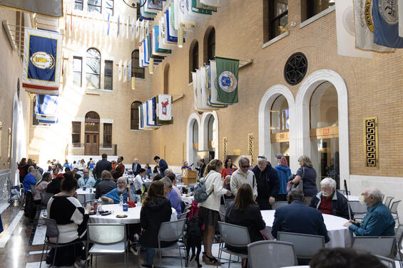 Attendees of the White Cane Awareness Day Celebration inside the Great Hall of the Massachusetts State House. The ceiling is lined with flags.