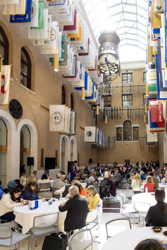 Attendees of the White Cane Awareness Day Celebration inside the Great Hall of the Massachusetts State House. The ceiling is lined with flags.
