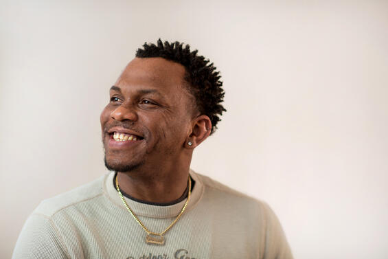 A black man smiles away from the camera