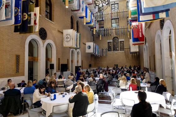 People sitting at tables and listening as a speaker stands at a podium during 2023 White Cane Awareness Day Celebration