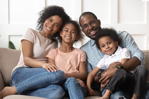 Family sitting on the couch smiling