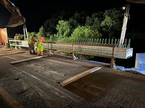View of deck beam and crew members at night.