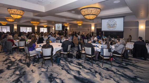 A panel of speakers present at the 2024 Health Tribal and Indigenous Health Summit to a room of audience members.