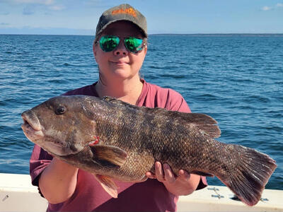A angler holding up her derby-winning tautog.