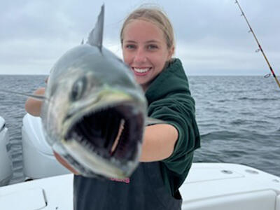 A young angler holding up her catch.