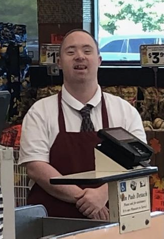 Craig Heller standing behind the register working at Market Basket.
