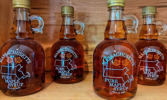 Four glass bottles of Massachusetts pure maple syrup.