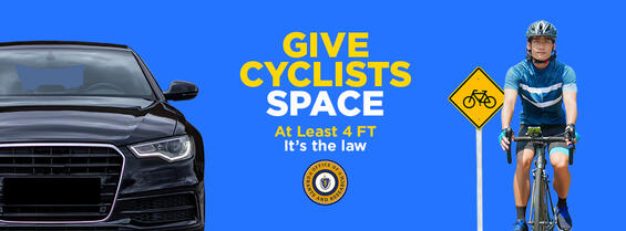 A car passes a bicyclist at a safe distance