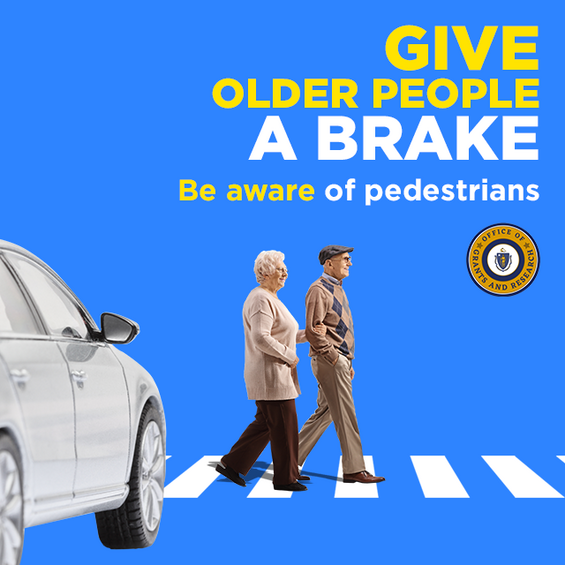 A car stops for elderly pedestrians on a crosswalk