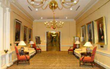 View of the Governor's office lobby with an ornate chandelier hanging from the ceiling and former governors' portraits hanging on the walls