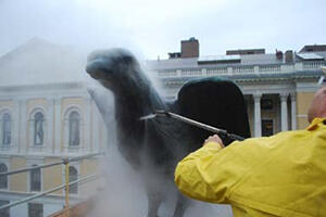 Bronze eagle is cleaned with high pressure water