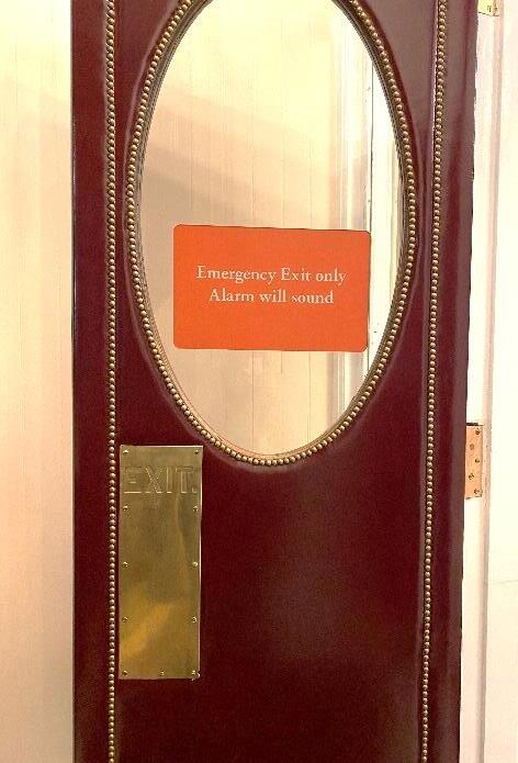 Close up of red leather door with an emergency exit sign