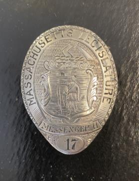Silver pin engraved with the words Massachusetts Legislature and the number 17