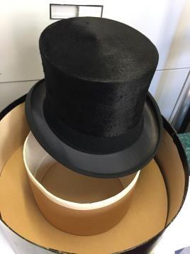 Silk top hat resting on top of a hat box