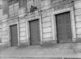 Entrance of the State Registry Building showing the seal above three large metal doors