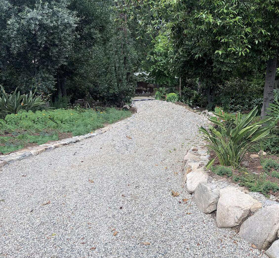 A curvy driveway made of pea gravel helps infiltrate water into the ground as well as slow the runoff from flowing in a straight line in a storm.