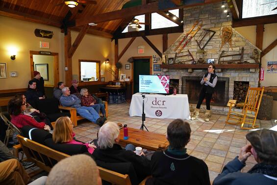 woman speaker with group by fireside