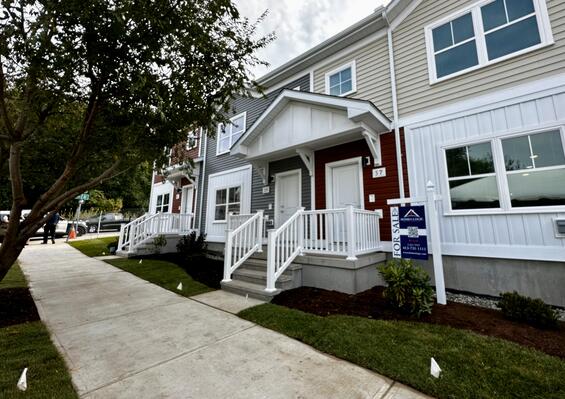 A block of new homes behind a sidewalk