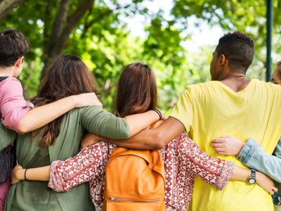 People standing with their arms around each other with their backs to the camera.