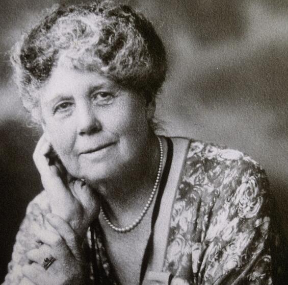 A portrait of Margaret Brooks Hutcheson posed smiling with one hand on her cheek and her head slightly tilted to the side.
