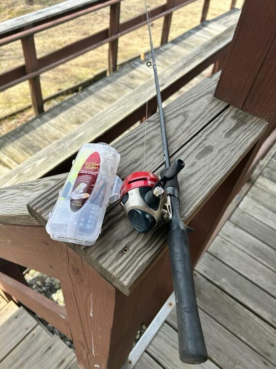a fishing rod and kit laying on a bench