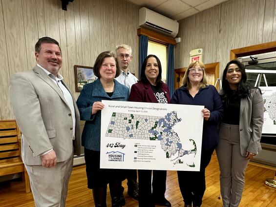 Secretary Juana Matias poses with legislators while holding a map of Massachusetts that has Housing Choice communities colored in. 