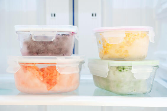 Vegetables and berries in glass boxes in the freezer close-up.