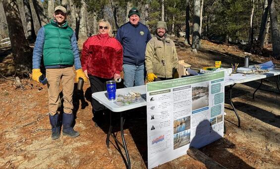 4 folks in winter gear standing behind a table with climate resilience information