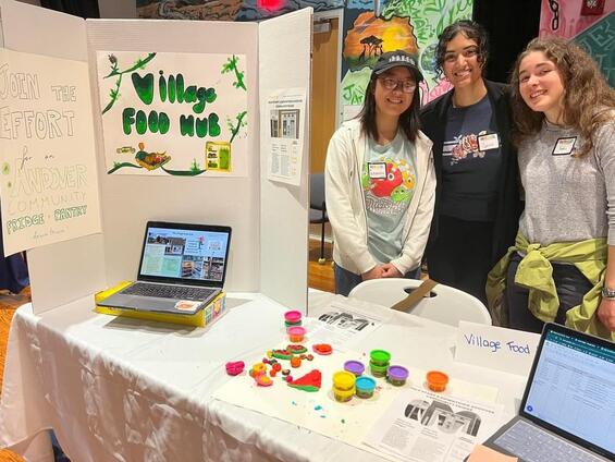 3 students standing with their community fridge display 