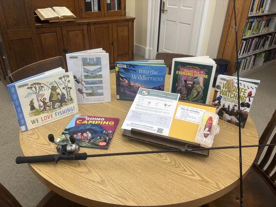 fishing rod and kit sitting on table with fishing books