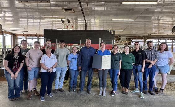 Commissioner Randle presents a Governor’s Proclamation to Herd Manager, Katelyn Lawrence and Farm Owner, Ed Almeida alongside MDAR Staff and members of the Agricultural Youth Council