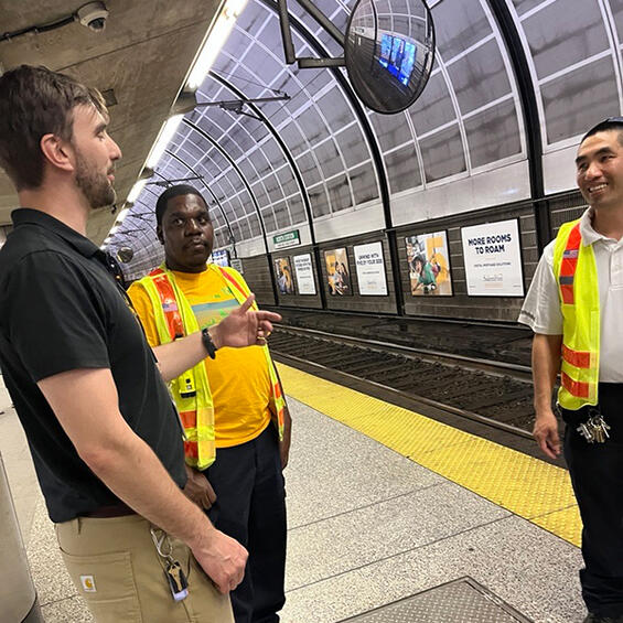 DPU talks with MBTA officials in yellow and orange safety vests.