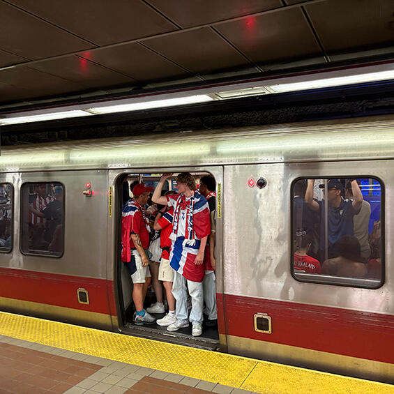 Soccer fans in red and white jerseys on the train.