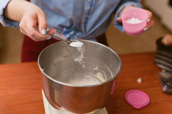 Adult adding baking soda to a bowl