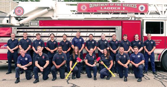20 new firefighters in front of a ladder truck
