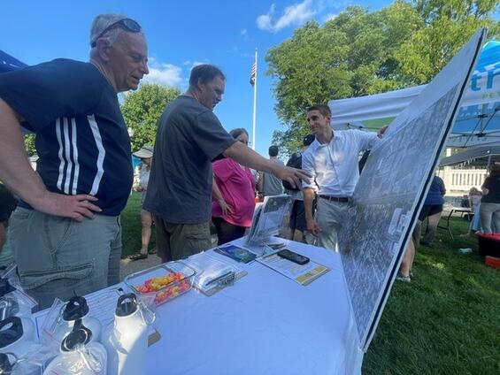 People looking at aerial overview image at Natick Nights booth