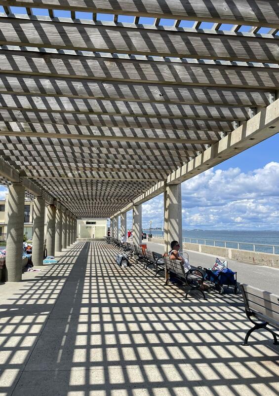 A structure along a beach provides shade for visitors