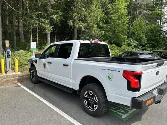 An electric DCR truck plugged into a charging station