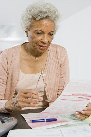 elderly woman calmly looking at a utility bill