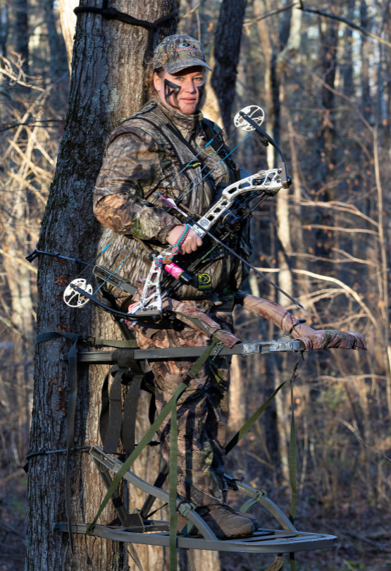 woman bowhunting from treestand
