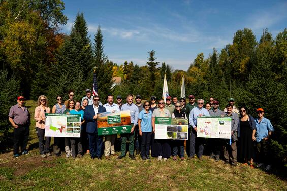 Group of people pose for a photo in field.
