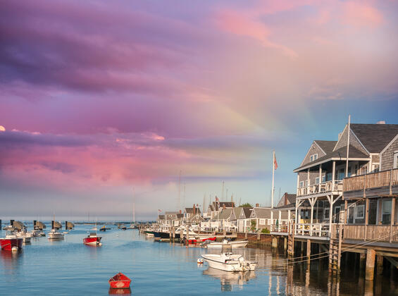 Houses along the water with a colorful sky on Nantucket. 