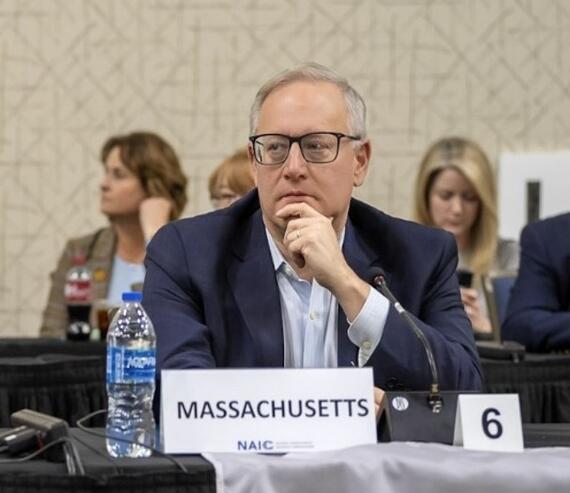 Commissioner Caljouw sitting at a table, listening during a meeting