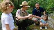 A park ranger speaking with children about nature.