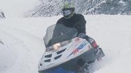 A snowmobile riding through snowy trails.