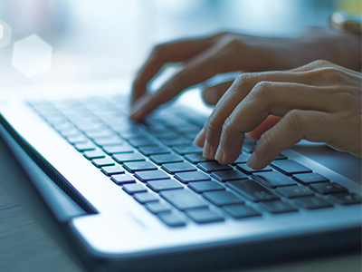 Hands typing on a laptop.